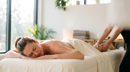 Athlete recevant un massage de recuperation apres un effort intense, illustrant l'evacuation des dechets metaboliques par le toucher therapeutique.